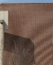 Eine Backsteinwand, die einen wirbelnden Effekt ähnlich Wellen zeigt, verursacht durch das Moire-Muster